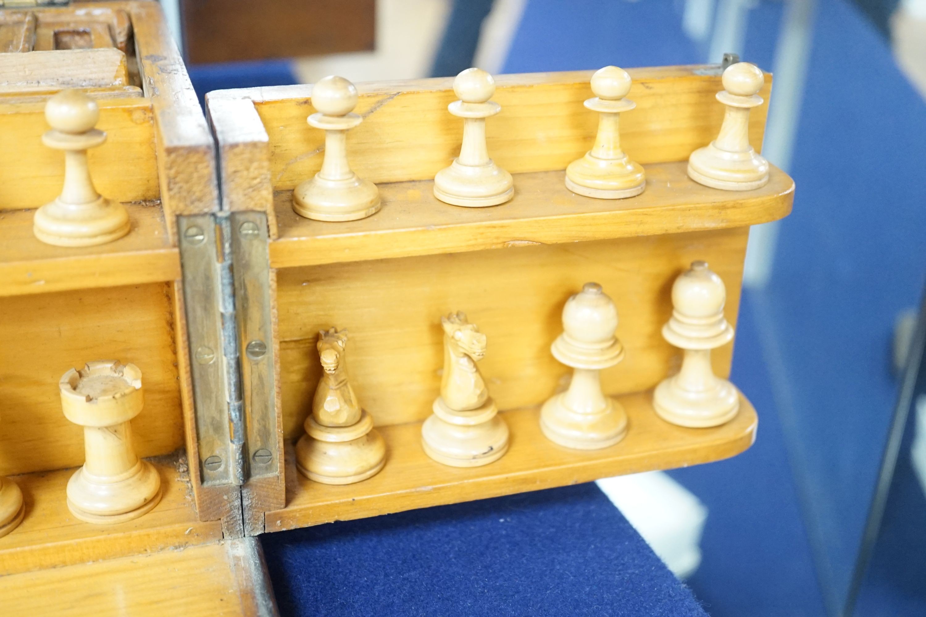 A 19th century mahogany games compendium with turned wood chess pieces and lead jockey and horse pieces